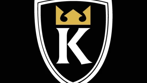 Logo of a black shield with a white border, featuring a gold crown above a white letter K in the center.